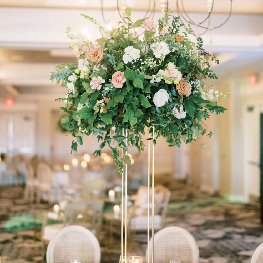 wedding table centerpiece with greenery, pink & white flowers, in hotel ballroom